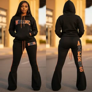 A full black and orange women's sweatsuit with a hoodie and flared bell-bottom pants, featuring an embroidered "NERNC" logo on the top and a "AERUS" logo on the back of the pants.