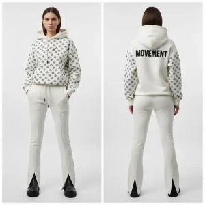 A full screen-printed off-white flared tracksuit set, featuring an all-over black monogram print on the sleeves and a prominent "MOVEMENT" logo on the back and pants leg.