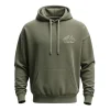 Front of an olive green oversized hoodie with a minimalist white line drawing of mountains and the text 'EXPLORE MORE' subtly printed on the chest.