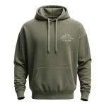 Front of an olive green oversized hoodie with a minimalist white line drawing of mountains and the text 'EXPLORE MORE' subtly printed on the chest.
