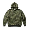 A comfortable, oversized pullover hoodie in a dense, realistic jungle camouflage pattern featuring various shades of green, brown, and khaki. It has a drawstring hood and a kangaroo pocket.