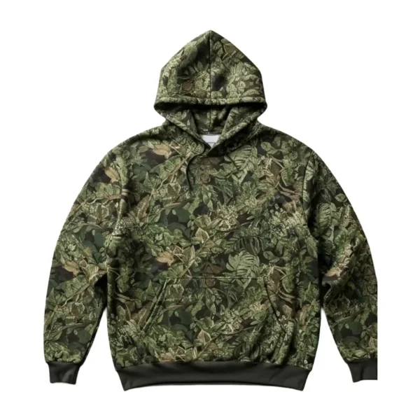 A comfortable, oversized pullover hoodie in a dense, realistic jungle camouflage pattern featuring various shades of green, brown, and khaki. It has a drawstring hood and a kangaroo pocket.