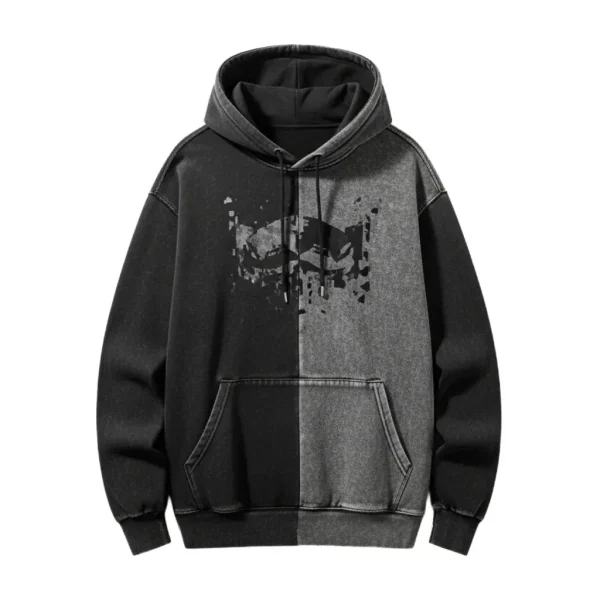 Front of a two-tone black and dark grey pullover hoodie with a contrasting split design, featuring a partial abstract splatter graphic on the chest.