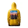 View of the back of the bright yellow sweatshirt, featuring a large, colorful graphic print of a vibrant city skyline at sunset, showcasing tall buildings against an orange and blue sky.