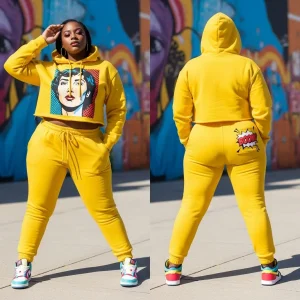 A woman wearing a bright yellow cropped tracksuit with a bold Pop Art graphic on the hoodie (DTG printed) and a playful "BOOM!" emblem on the back of the joggers.