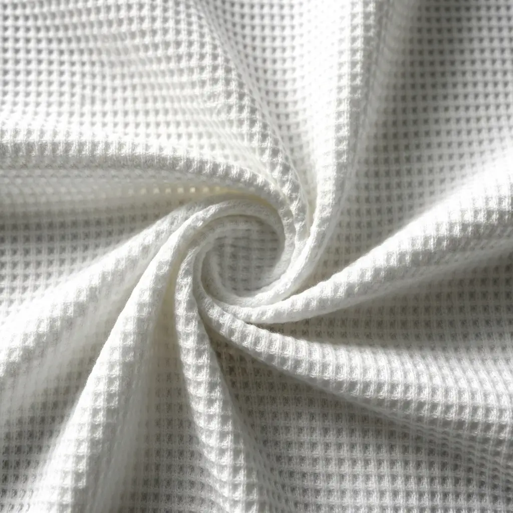 Closeup of white polyester waffle knit fabric twisted.