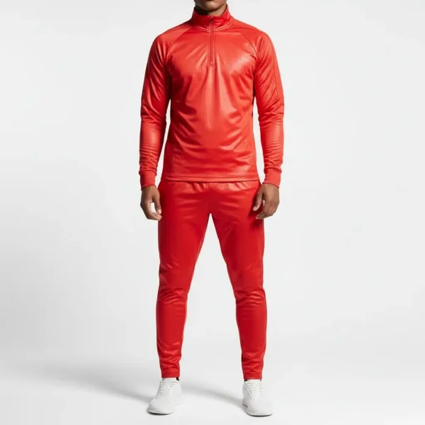 Man posing in a bright fluorescent red slim-fit nylon tracksuit with a quarter-zip collar.