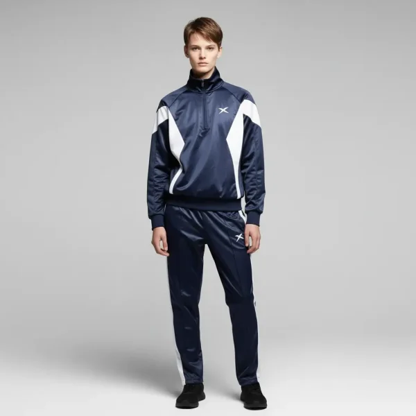 Athletic navy blue nylon tracksuit with sharp white geometric contrast panels and a minimalist logo on the chest.