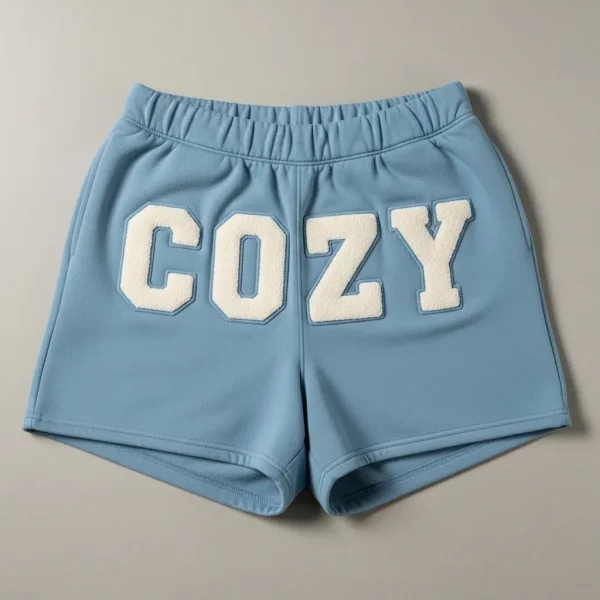 Bright blue cotton sweat shorts featuring premium white chenille letters "COZY".
