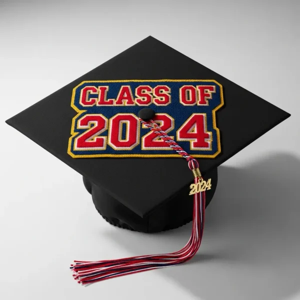 A studio shot mortarboard graduation cap decorated with a school chenille patch and the graduation year.