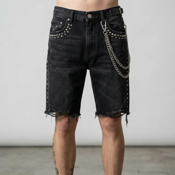 Front view of heavyweight denim jorts embellished with metallic studs and decorative side chains for a punk-inspired look.