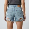 Back view of heavily distressed and ripped denim shorts with frayed hems and light wash finish.