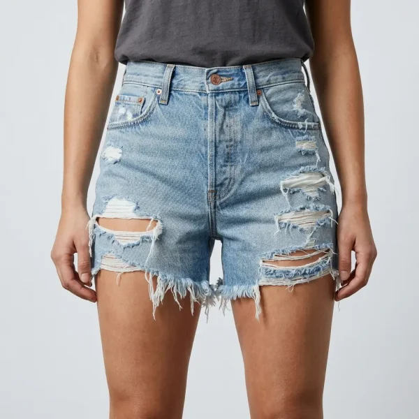 Front view of heavily distressed and ripped denim shorts with frayed hems and light wash finish.
