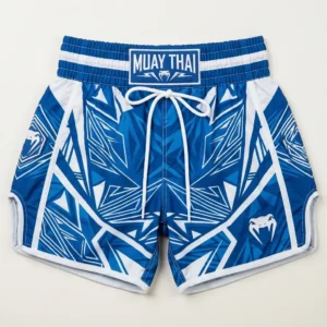 Front view of blue Venum Muay Thai shorts with a geometric pattern, white drawstring ties, and the iconic snake head brand logo.