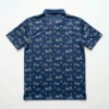 Back view of a navy blue short-sleeve polo shirt featuring a repeating pattern of various vintage and modern motorcycles and helmets.