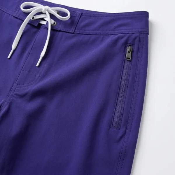 Zippered side pocket closeup on purple board shorts.