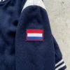 Embroidered flag patch on varsity jacket sleeve.