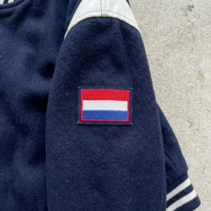 Embroidered flag patch on varsity jacket sleeve.
