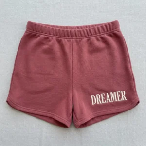 Front view of custom embroidered booty shorts in pink color with text embroidered on it.