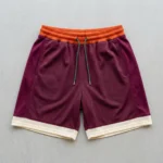 Custom orange, maroon, and cream color block basketball shorts front.