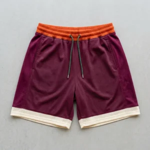 Custom orange, maroon, and cream color block basketball shorts front.