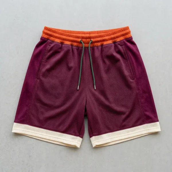 Custom orange, maroon, and cream color block basketball shorts front.