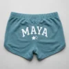 Light teal custom rhinestone booty shorts back with screen printed text and rhinestones around it.