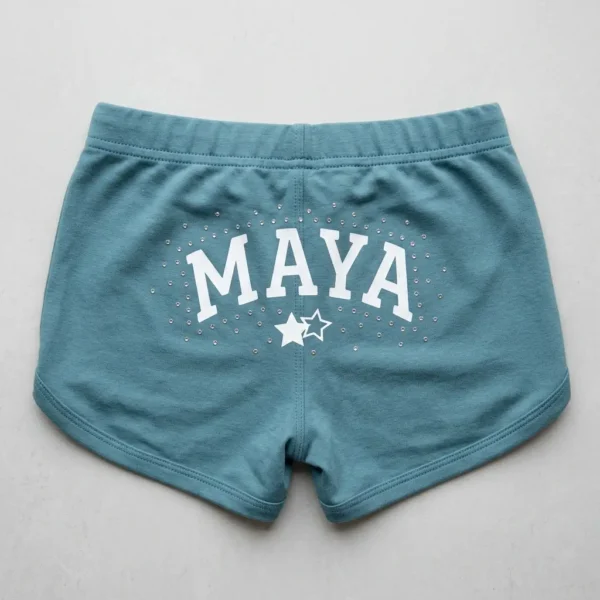 Light teal custom rhinestone booty shorts back with screen printed text and rhinestones around it.
