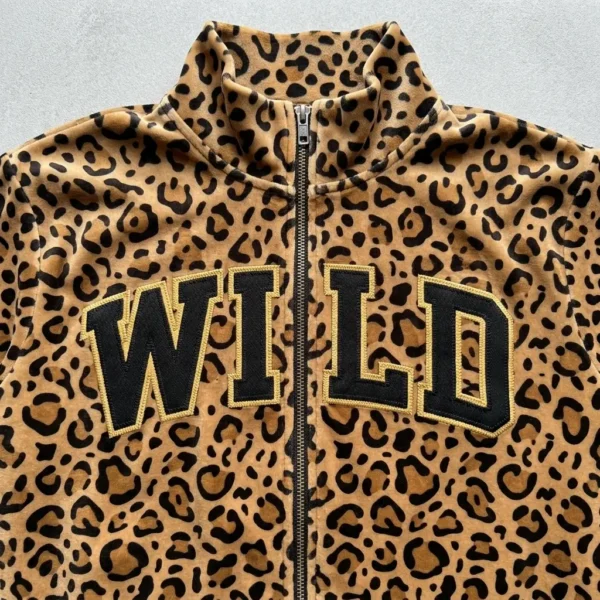 A closeup of leopard printed velour track jacket with applique/tackle twill letters "WILD" on the chest.
