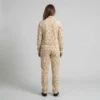 Back view of a woman wearing beige textured spotted animal print velour tracksuit.
