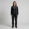 Front view of a woman wearing black charcoal spotted animal print velour tracksuit.
