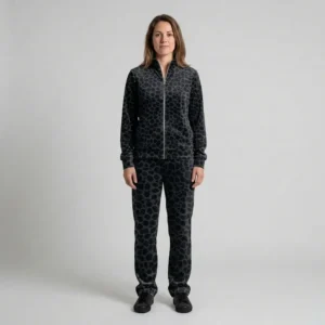Front view of a woman wearing black charcoal spotted animal print velour tracksuit.