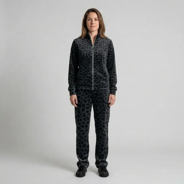 Front view of a woman wearing black charcoal spotted animal print velour tracksuit.