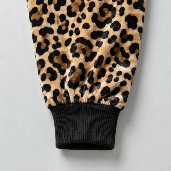 Close up of black color cuff of a leopard printed velour track jacket.