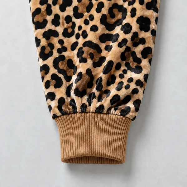 Close up of caramel color ribbed cuff of a leopard printed velour track jacket.