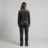 Back view of a woman wearing charcoal tonal spotted animal print velour tracksuit.