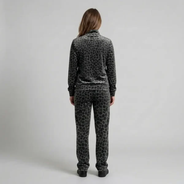 Back view of a woman wearing charcoal tonal spotted animal print velour tracksuit.
