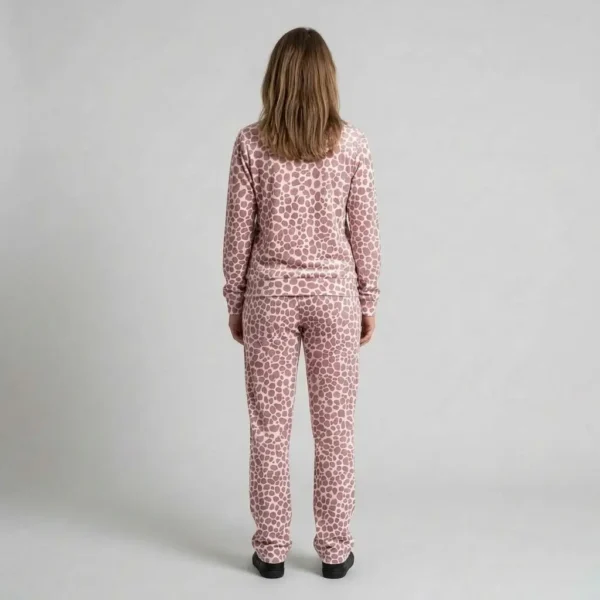 Back view of a woman wearing dusty rose spotted animal print velour tracksuit.