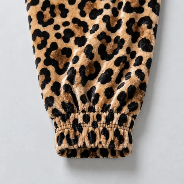 Close up of elasticated cuff of a leopard printed velour track jacket.