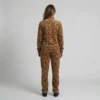 Back view of a woman wearing golden tan leopard print velour tracksuit.