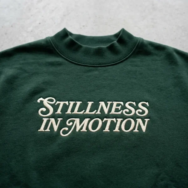 Green embroidered sweatshirt closeup.