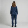 Back view of a woman wearing navy blue spotted animal print velour tracksuit.