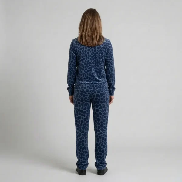 Back view of a woman wearing navy blue spotted animal print velour tracksuit.