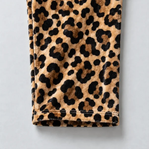 Close up of open hem of a leopard print velour track pants.