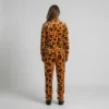 Back view of a woman wearing orange leopard print velour tracksuit.