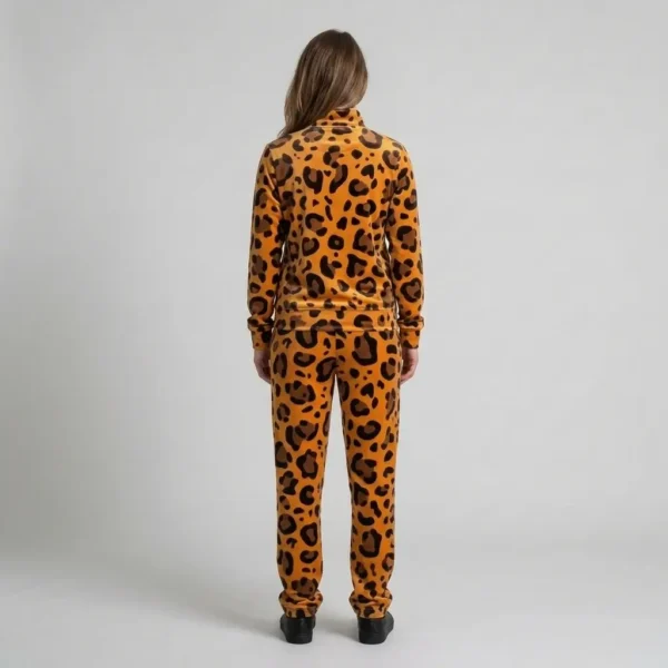 Back view of a woman wearing orange leopard print velour tracksuit.