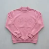 Pink embossed mock neck sweatshirt front.