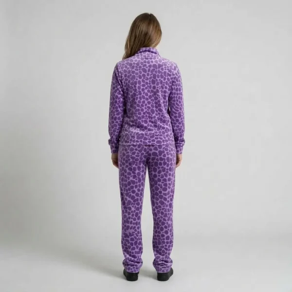 Back view of a woman wearing purple spotted animal print velour tracksuit.