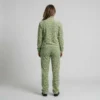 Back view of a woman wearing sage green spotted animal print velour tracksuit.