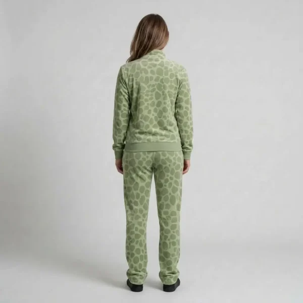 Back view of a woman wearing sage green spotted animal print velour tracksuit.